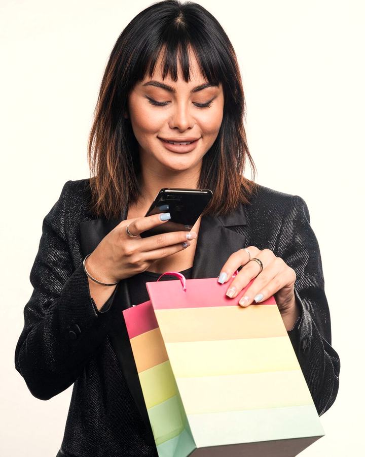 A customer checking her order on her phone after buying